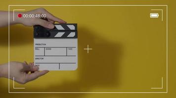 filma skiffer eller film clapperboard slå i främre av bio kamera inspelning. stänga upp hand innehav tömma filma skiffer och applåder Det. öppen och stänga filma skiffer för video produktion. filma produktion.