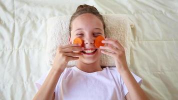 Beautiful girl with facial mask of carrot. Top view. video