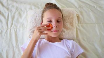 Beautiful girl with facial mask of carrot. Top view. video
