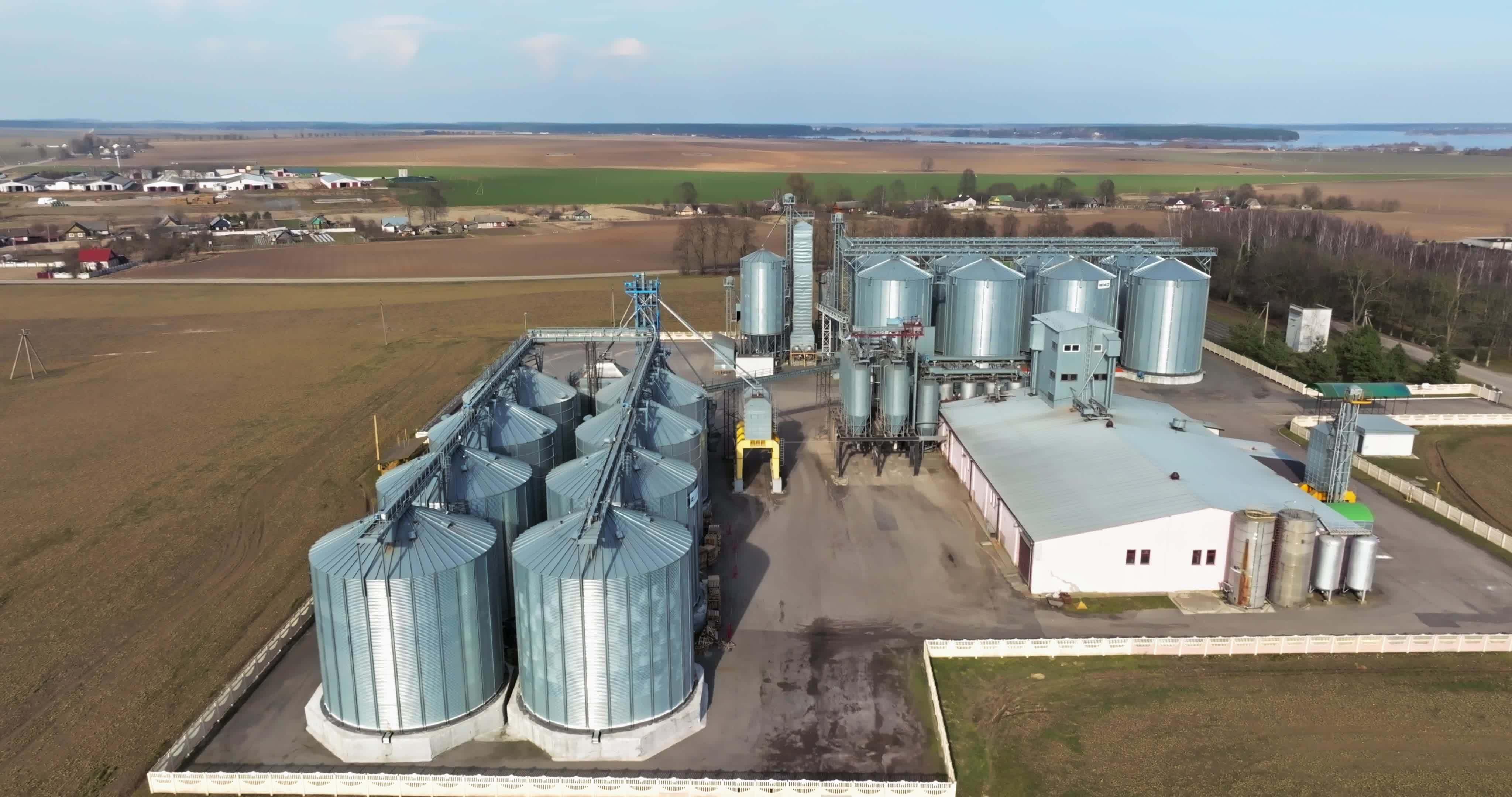 aerial view over agroindustrial complex with silos and grain drying
