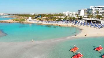 aéreo ver mujer turista caminar en hermosa nisi playa en Chipre. famoso viaje visitar destino. popular famoso blanco arena playa. solo viajero visitar nisi isla playa video