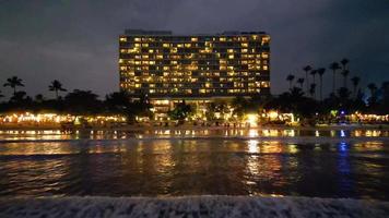 hotel luces reflexión en Oceano olas a noche por zumbido video