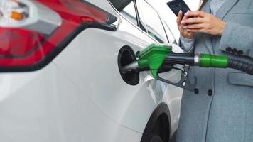 donna riempimenti benzina in sua auto a un' gas stazione avvicinamento video