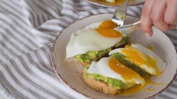 rebanar brindis con aguacate y huevo. líquido yema de huevo fluido. sano vegano desayuno. video