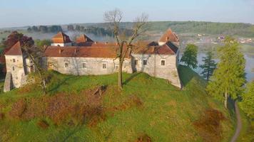 Aerial view of Svirzh castle near Lviv, Ukraine in morning fog at dawn. Lake and surrounding landscape at sunrise. video
