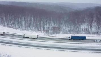 Haut vue de circulation sur une route entouré par hiver forêt. scénique hiver paysage video
