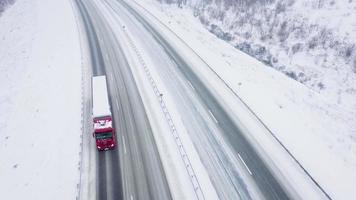 Top view of traffic on a road surrounded by winter forest. Scenic winter landscape video