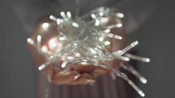 Woman holds white christmas garland in hands close up video