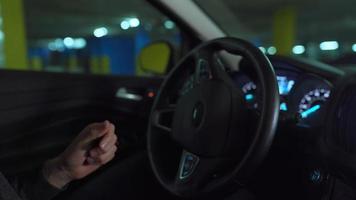 Man driving in innovative automated car using self-parking autopilot for parking on parking lot. Robotic computer turning wheel in autosteering mode video