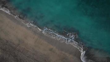 Antenne Aussicht von das Wüste schwarz Strand auf das atlantisch Ozean. Küste von das Insel von Teneriffa, Kanarienvogel Inseln, Spanien. Antenne Drohne Aufnahmen von Meer Wellen erreichen Ufer. video
