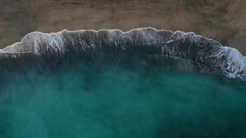 aereo Visualizza di il deserto nero spiaggia su il atlantico oceano. costa di il isola di tenerife, canarino isole, Spagna. aereo fuco metraggio di mare onde raggiungendo costa. video