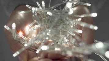 Woman holds white christmas garland in hands close up video