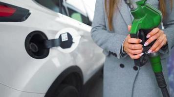 vrouw vult benzine in haar auto Bij een gas- station detailopname video