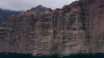 aéreo ver de los gigantes acantilados en tenerife en nublado clima, canario islas, España. acelerado vídeo video