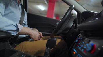 Man driving in innovative automated car using self-parking autopilot for parking on parking lot. Robotic computer turning wheel in autosteering mode video