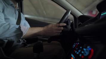 Man driving in innovative automated car using self-parking autopilot for parking on parking lot. Robotic computer turning wheel in autosteering mode video