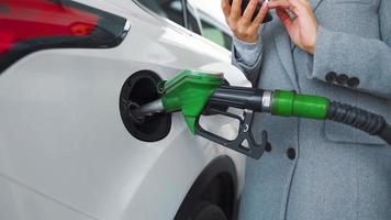 donna riempimenti benzina in sua auto a un' gas stazione avvicinamento video