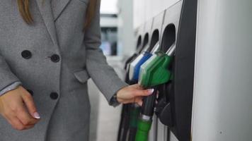 Woman fills petrol into her car at a gas station close-up video