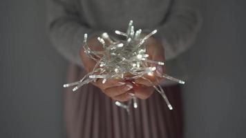 Woman holds white christmas garland in hands close up video