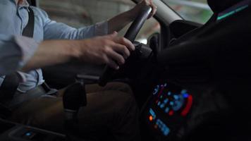 Man driving in innovative automated car using self-parking autopilot for parking on parking lot. Robotic computer turning wheel in autosteering mode video