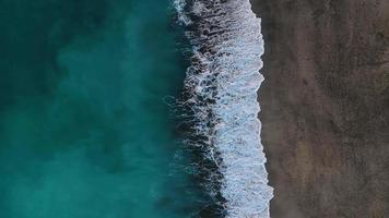 antenn se av de öken- svart strand på de atlanten hav. kust av de ö av teneriffa, kanariefågel öar, Spanien. antenn Drönare antal fot av hav vågor nå Strand. video