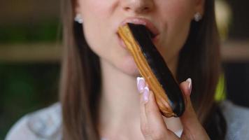 Caucasian woman eating chocolate eclair in a cafe video