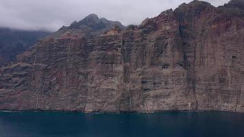 Aerial view of Los Gigantes Cliffs on Tenerife in cloudy weather, Canary Islands, Spain. Accelerated video