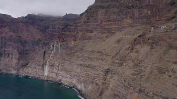 Aerial view of Los Gigantes Cliffs on Tenerife in cloudy weather, Canary Islands, Spain. Accelerated video