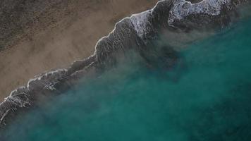 antenn se av de öken- svart strand på de atlanten hav. kust av de ö av teneriffa, kanariefågel öar, Spanien. antenn Drönare antal fot av hav vågor nå Strand. video