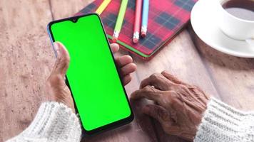 Senior woman hand using smart phone close up video
