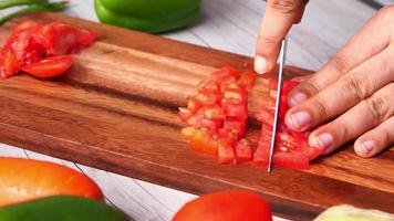 vicino su di uomo affettare fresco pomodoro su chopping tavola video