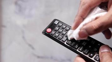 man hand cleaning TV remote controller with disinfectant wet wipe video