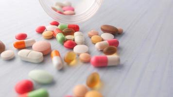 Close up di pillole colorate fuoriuscita su sfondo bianco video