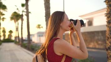 Photographer tourist woman taking photos with camera in a beautiful tropical landscape at sunset video