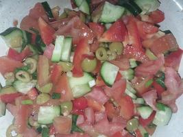 Preparing a dietary vegan salad with fresh vegetables photo