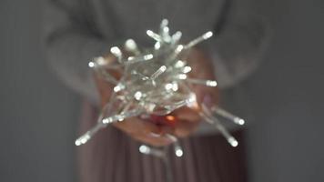 Woman holds white christmas garland in hands close up video