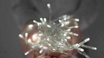 Woman holds white christmas garland in hands close up video