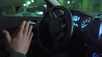 Man driving in innovative automated car using self-parking autopilot for parking on parking lot. Robotic computer turning wheel in autosteering mode video