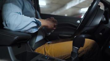 Man driving in innovative automated car using self-parking autopilot for parking on parking lot. Robotic computer turning wheel in autosteering mode video
