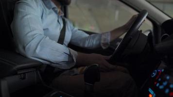 Man driving in innovative automated car using self-parking autopilot for parking on parking lot. Robotic computer turning wheel in autosteering mode video