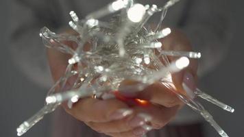 Woman holds white christmas garland in hands close up video