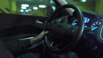 Man driving in innovative automated car using self-parking autopilot for parking on parking lot. Robotic computer turning wheel in autosteering mode video