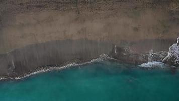 Antenne Aussicht von das Wüste schwarz Strand auf das atlantisch Ozean. Küste von das Insel von Teneriffa, Kanarienvogel Inseln, Spanien. Antenne Drohne Aufnahmen von Meer Wellen erreichen Ufer. video