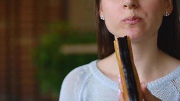 Caucasian woman eating chocolate eclair in a cafe video