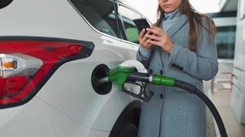 femme remplit essence dans sa voiture à une gaz station fermer video