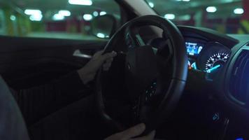 Man driving in innovative automated car using self-parking autopilot for parking on parking lot. Robotic computer turning wheel in autosteering mode video