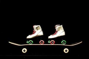 A skateboard and a pair of skates photo