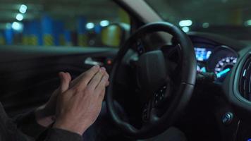Man driving in innovative automated car using self-parking autopilot for parking on parking lot. Robotic computer turning wheel in autosteering mode video