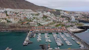 Antenne Aussicht von los Giganten, Aussicht von das Yachthafen und das Stadt. Abfahrt von das Küste gegenüber das Ozean. Teneriffa, Kanarienvogel Inseln, Spanien video