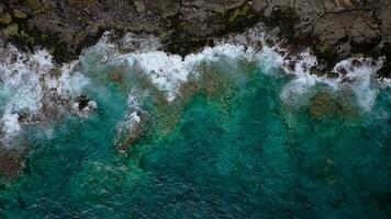 parte superior ver de un abandonado costa. rocoso apuntalar de el isla de tenerife, canario islas, España. aéreo zumbido imágenes de Oceano olas alcanzando apuntalar video